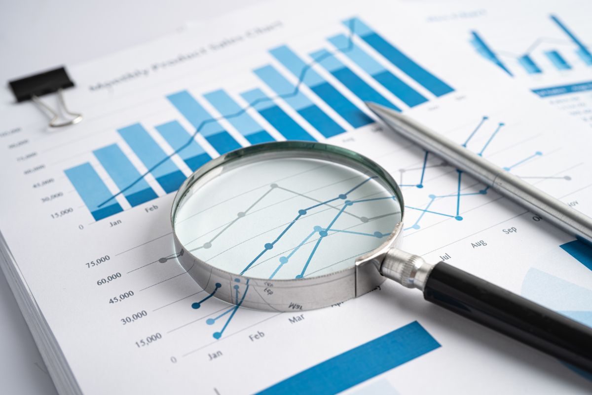 An upward going chart looked through a magnifying glass visualizing the benefits of hiring an inbound marketing consultant.