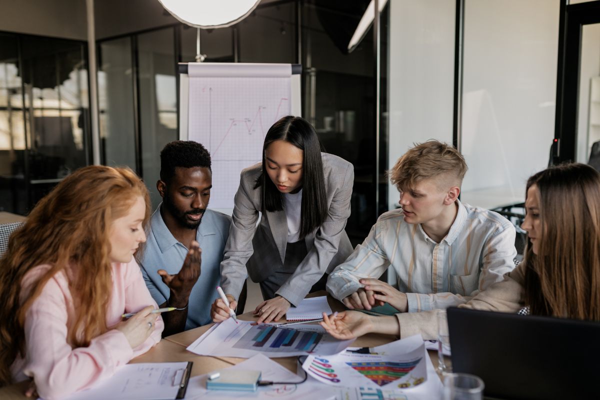 A group of marketers sitting around a table full of charts trying to create an inbound marketing funnel.