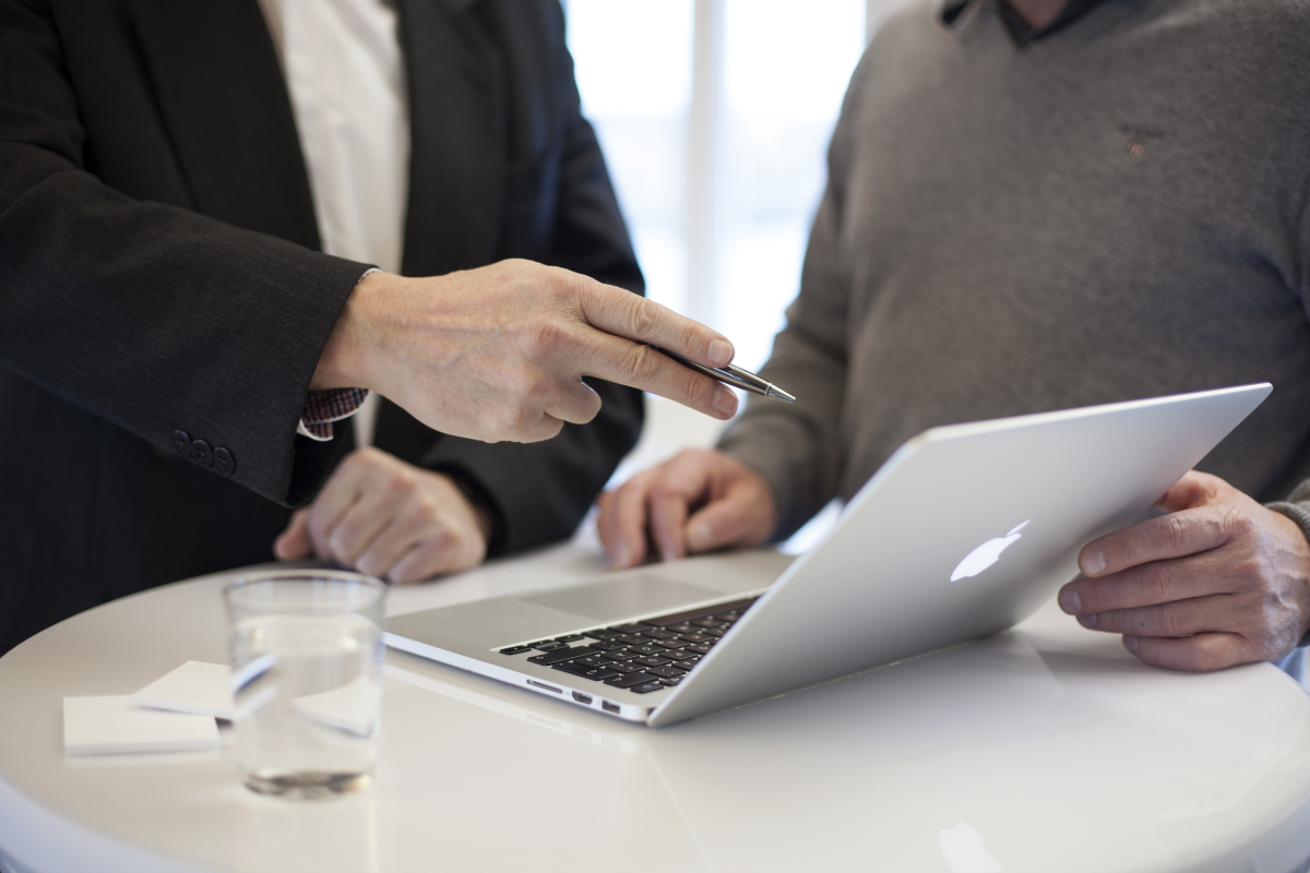 An inbound marketing consultant standing next to a client in front of a laptop.