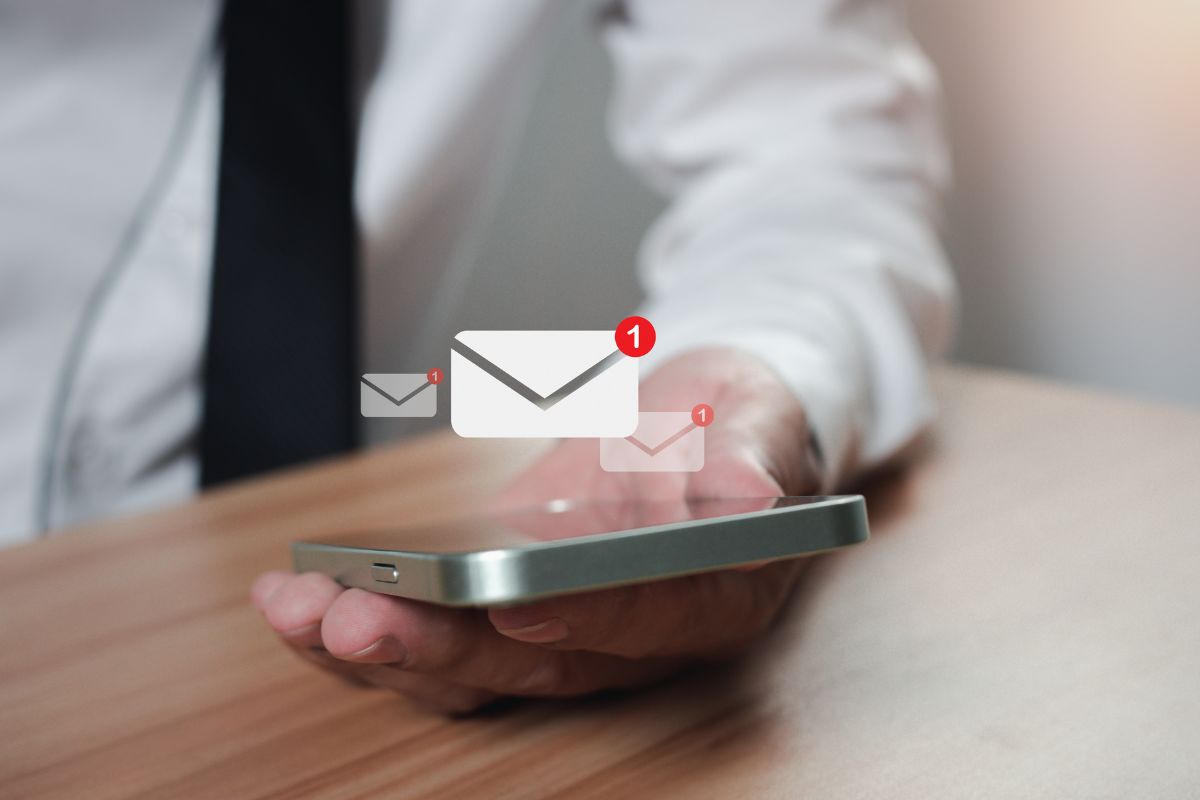 A man in a suit looking at his phone after being subjected to inbound email marketing.