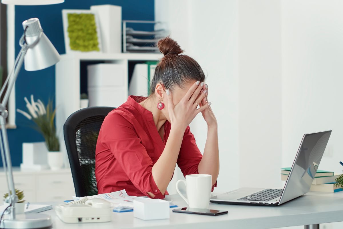 A woman holding her head in disappointment after falling for the common pitfalls for generating inbound leads. 