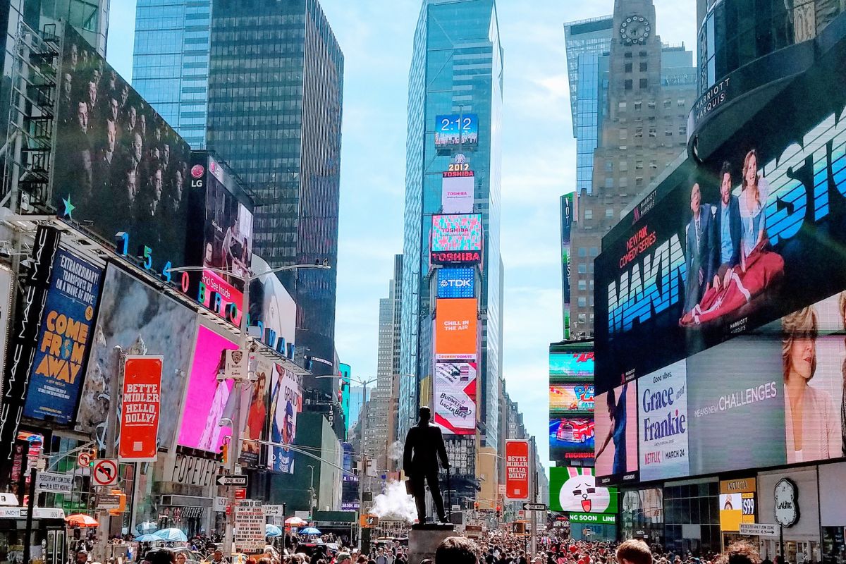 A photo of Times Square in New York full of billboards and people ignoring them.